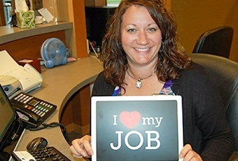 Team member with I love my job sign