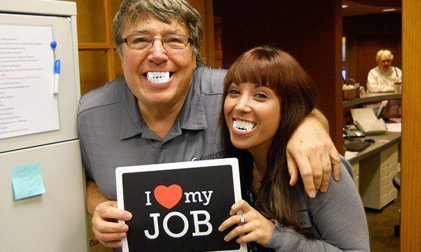 Team members holding I love my job sign