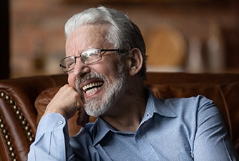 Senior man resting on couch smiling