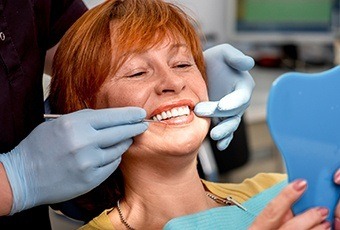 Woman and dentist looking at smile in mirror