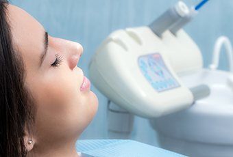 Woman with eyes closed relaxing in dental chair