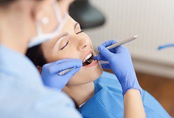 Woman with eyes closed receiving dental care