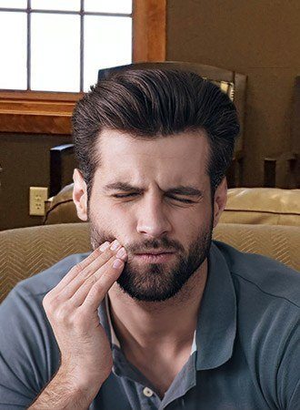 Man in pain holding cheek