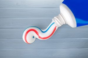toothpaste squirting from tube on toothbrush