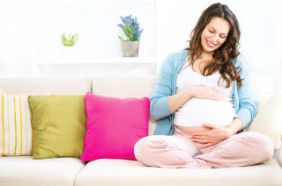 Smiling pregnant woman on the couch