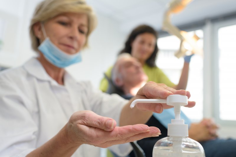 an emergency dentist in Ripon using hand sanitizer before assisting a patient