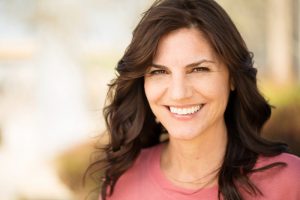 Woman smiling with dental implants in Ripon while outside