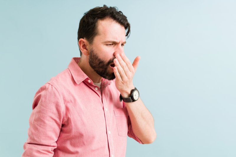 a man smelling his bad breath